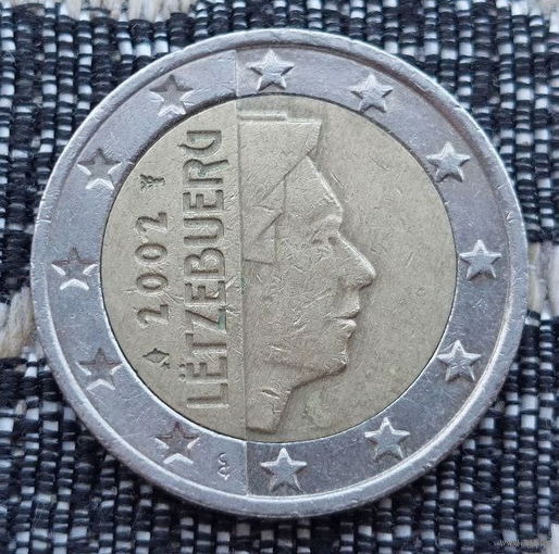 Люксембург 2 евро 2002 года. Король. Клеймо Гастауер-Клер Иветта. Лук со стрелой и звёздочкой и Посох Меркурия.
