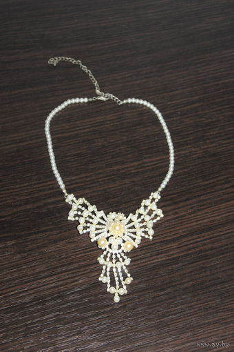 Пластиковое колье с металлической подвеской.