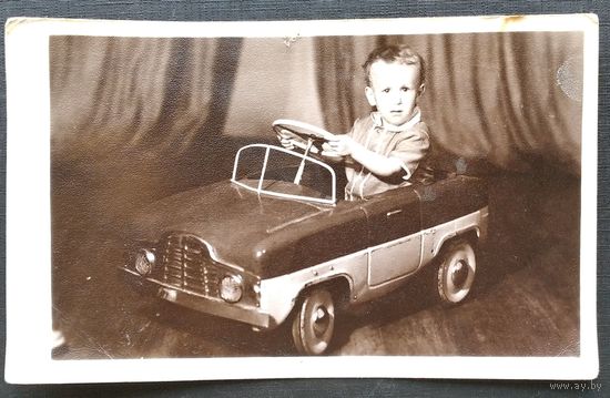 Фото мальчика на педальной машинке. 9х14 см.